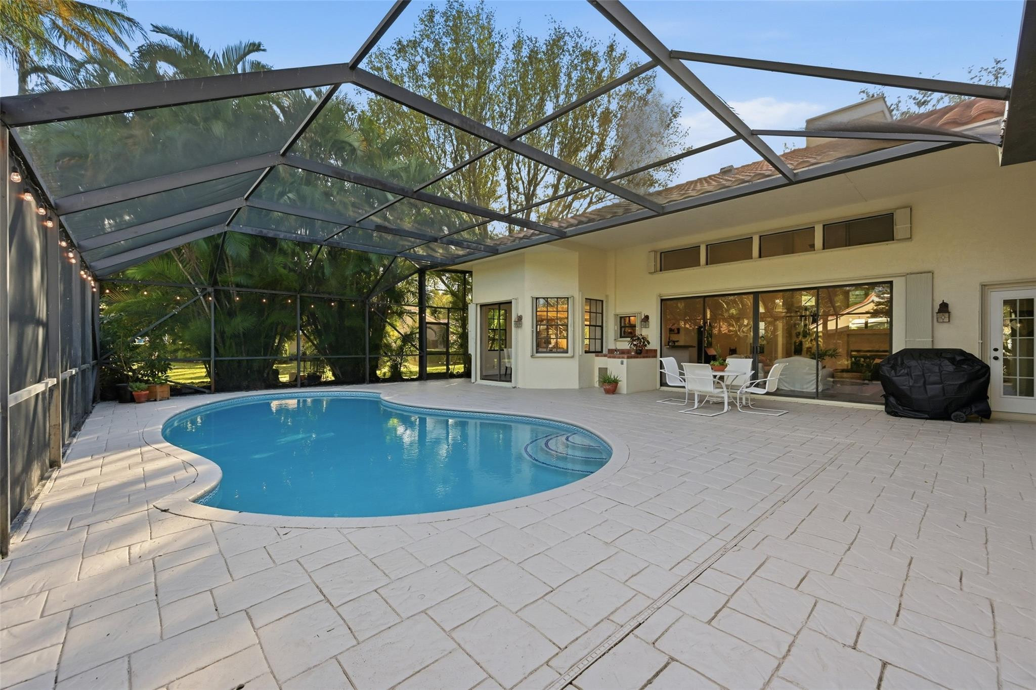 7720 West Upper Ridge Drive Parkland, FL 33067 - Photo 57 of 85 a view of a patio with a table and chairs