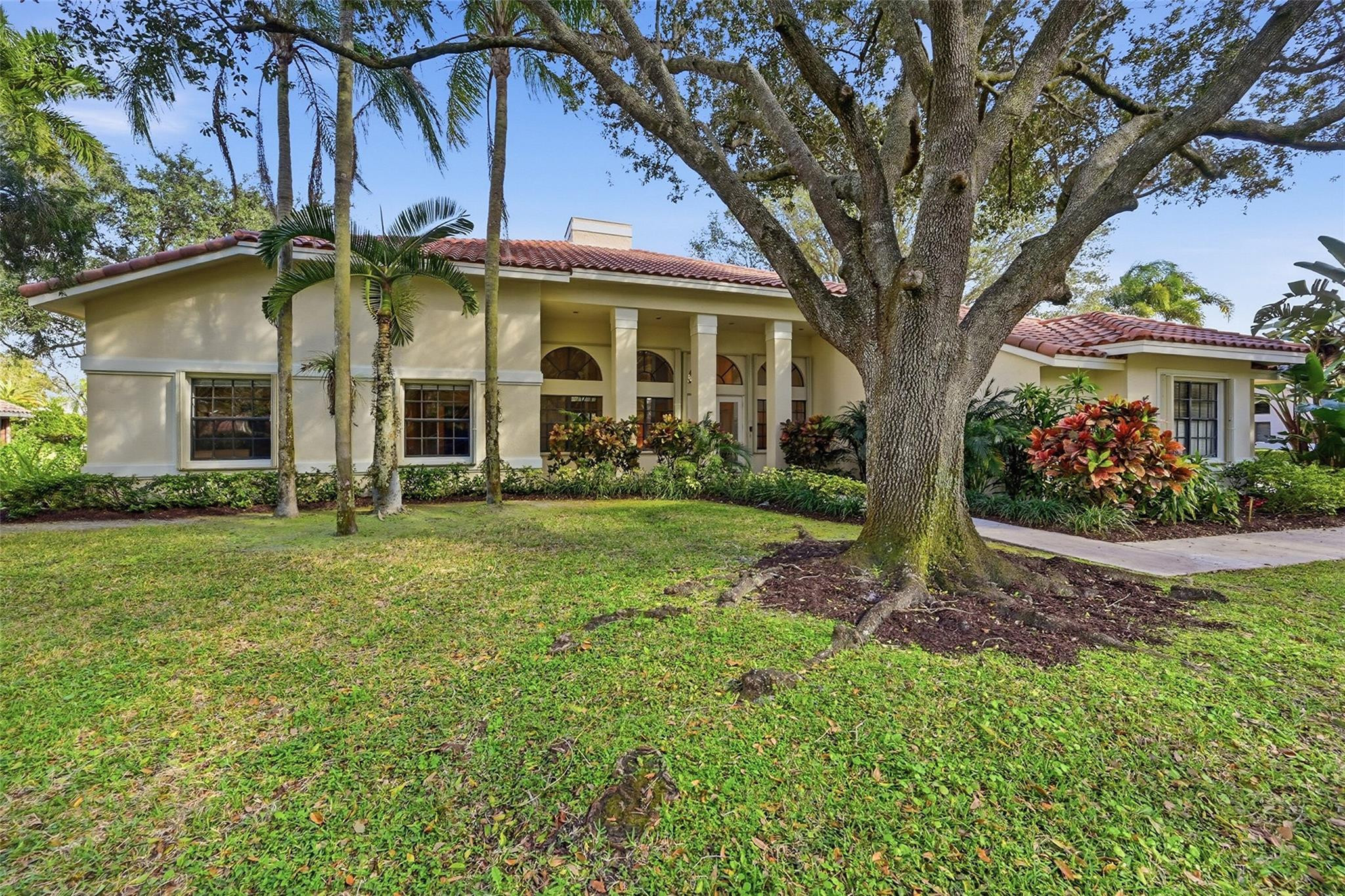 7720 West Upper Ridge Drive Parkland, FL 33067 - Photo 6 of 85 a view of a white house with a big yard and large tree