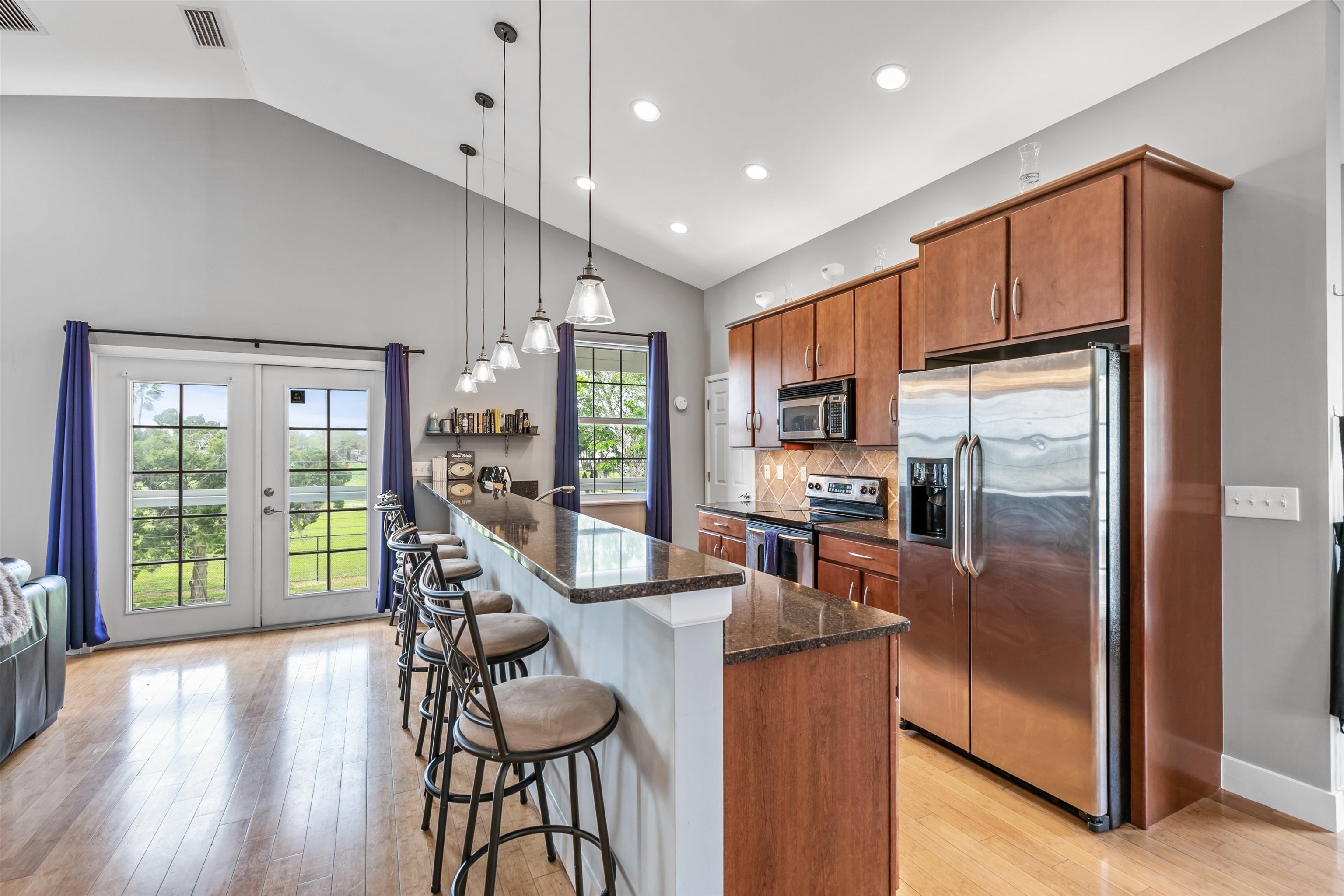 171 Riberia Street St. Augustine, FL 32084 - Photo 17 of 33 a kitchen with granite countertop stainless steel appliances a refrigerator a stove top oven and a dining table with wooden floor