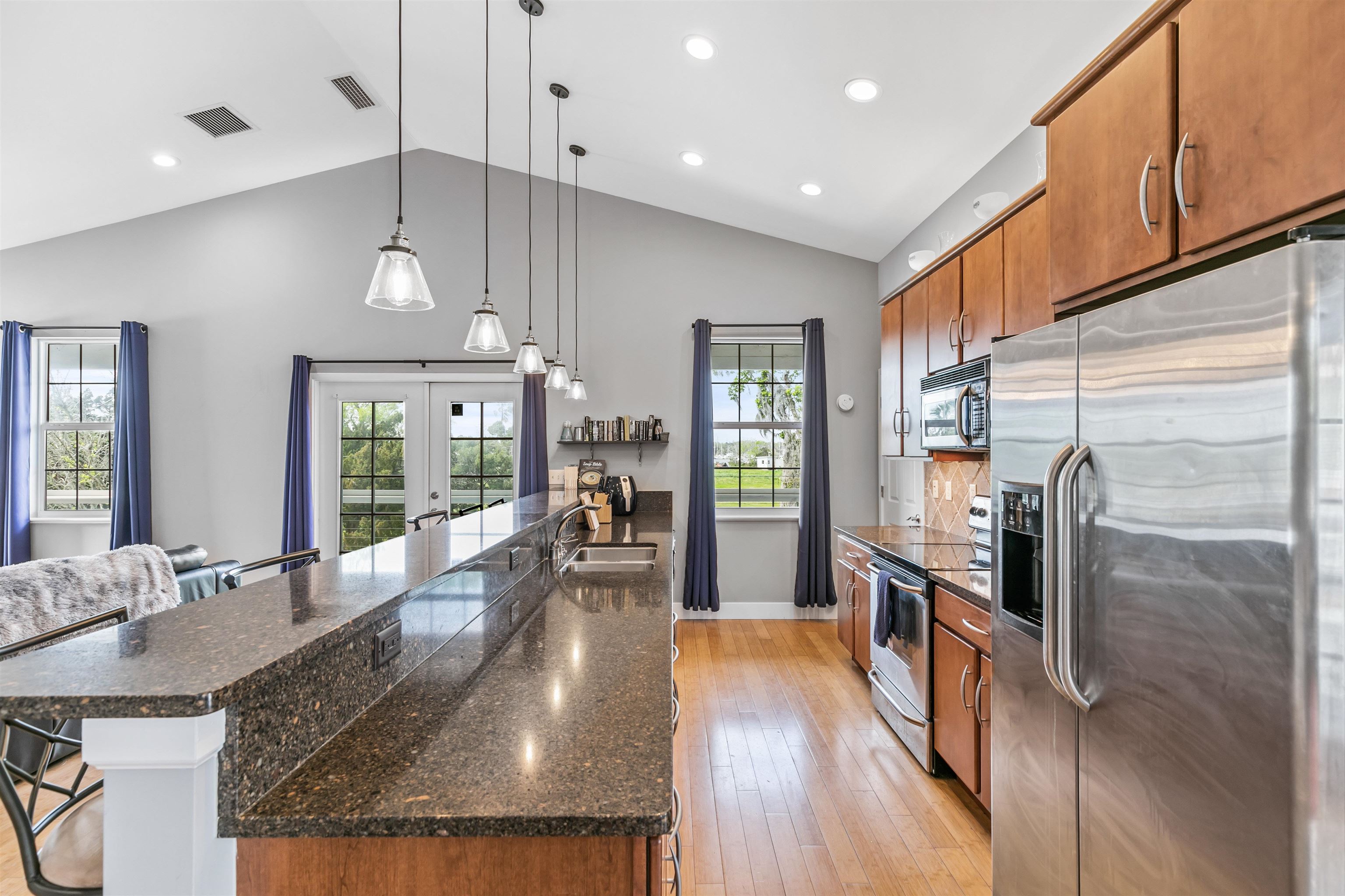 171 Riberia Street St. Augustine, FL 32084 - Photo 19 of 33 a kitchen with stainless steel appliances granite countertop a refrigerator a sink dishwasher a stove and a dining table with wooden floor