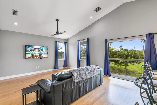 a living room with furniture a flat screen tv and a large window