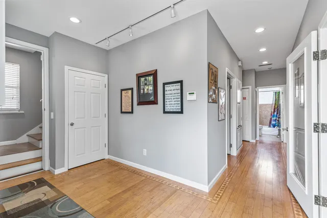 a view of a hallway with wooden floor and windows