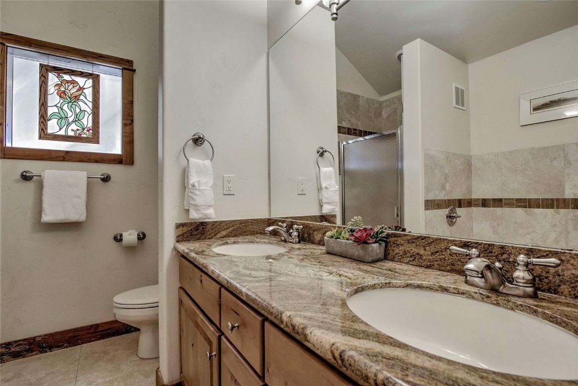 65 Antler Gulch Road, Unit 502 Keystone, CO 80435 - Photo 22 of 41 a bathroom with a granite countertop sink a toilet and a mirror