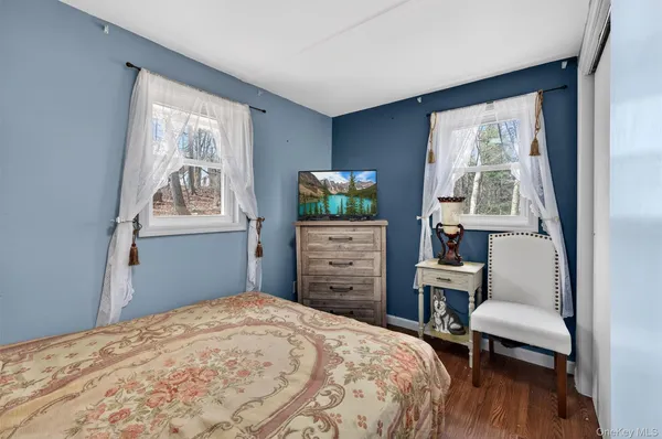 a bedroom with a bed window and a chair