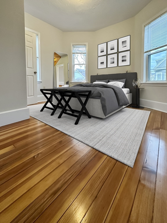 55 Hollander Street, Unit 2 Boston, MA 02121 - Photo 5 of 8 a bedroom with a bed a table and chair