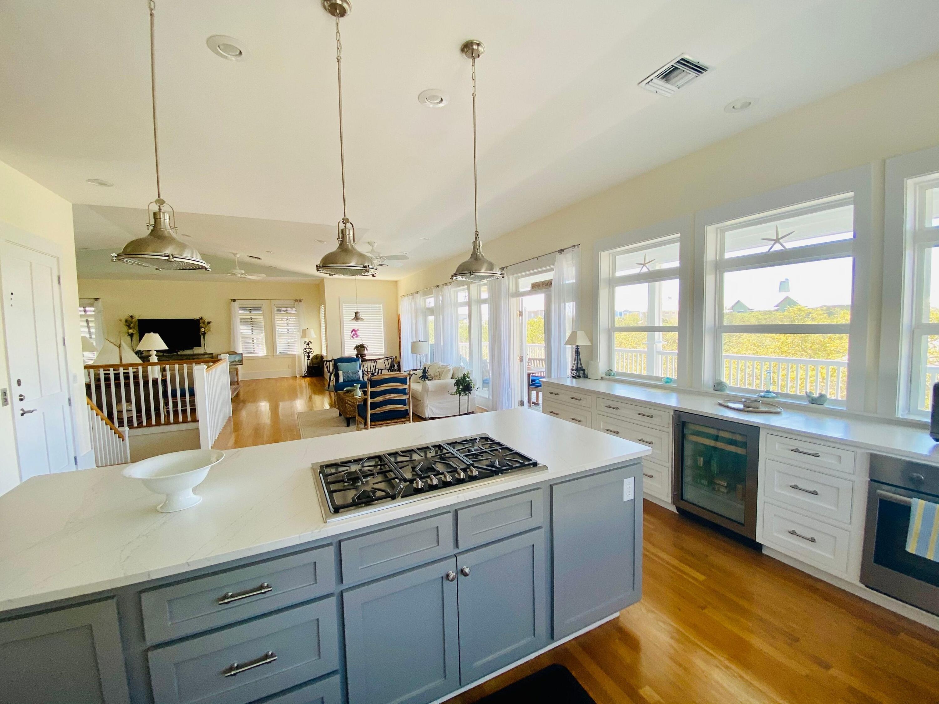 170 Old Beach Road Santa Rosa Beach, FL 32459 - Photo 5 of 35 a kitchen with stainless steel appliances kitchen island granite countertop a stove a sink dishwasher and white cabinets with wooden floor