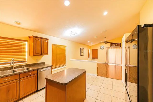 a kitchen with a sink refrigerator and cabinets