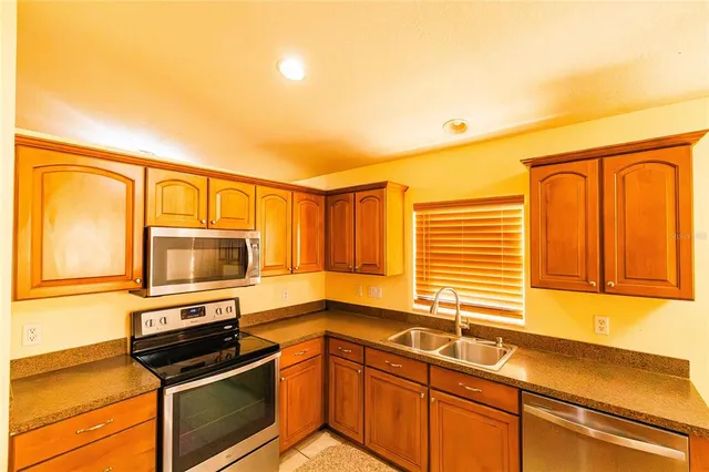 a kitchen with stainless steel appliances granite countertop a stove a sink and a microwave
