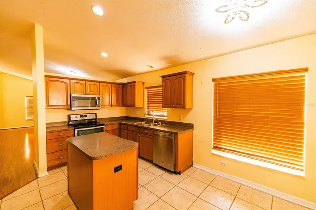 a kitchen with stainless steel appliances granite countertop a stove a sink and a refrigerator