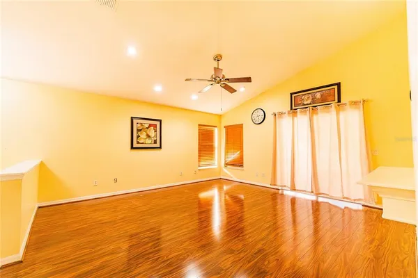 a view of an empty room with wooden floor