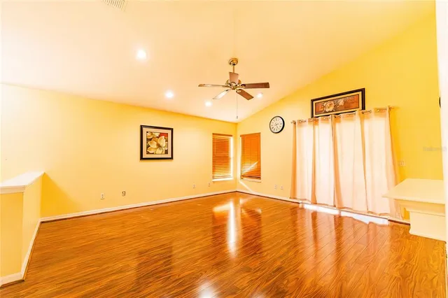 a view of an empty room with wooden floor