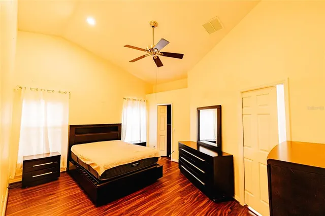 a bedroom with a bed and wooden floor