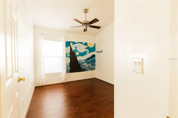 a view of a hallway with wooden floor and a potted plant