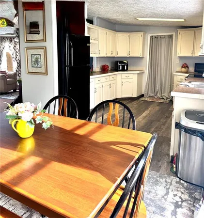 a kitchen with stainless steel appliances kitchen island granite countertop a table chairs and a wooden cabinets