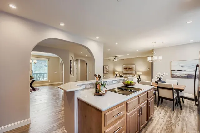 a living room with furniture and a dining table with wooden floor