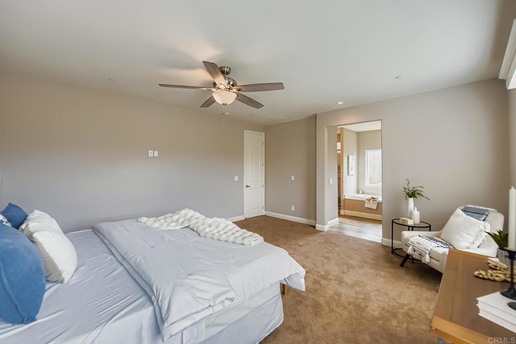 28720 North Twin Oaks Valley Road Vista, CA 92084 - Photo 27 of 66 a spacious bedroom with a bed and a chandelier