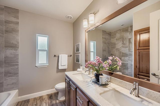 a bathroom with a sink vanity mirror and toilet
