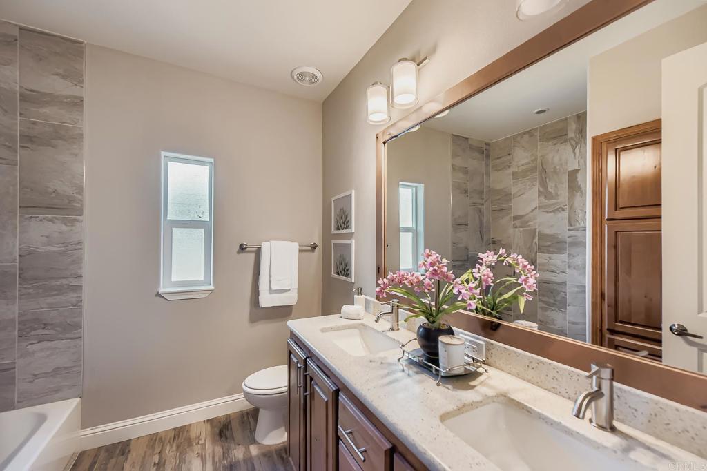 28720 North Twin Oaks Valley Road Vista, CA 92084 - Photo 40 of 66 a bathroom with a granite countertop sink toilet and large mirror