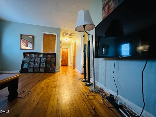 a view of a big room with wooden floor and brick walls