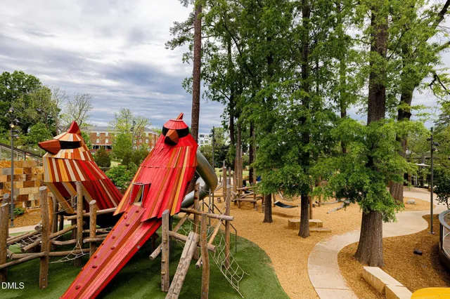 a view of a house with large windows and flower plants