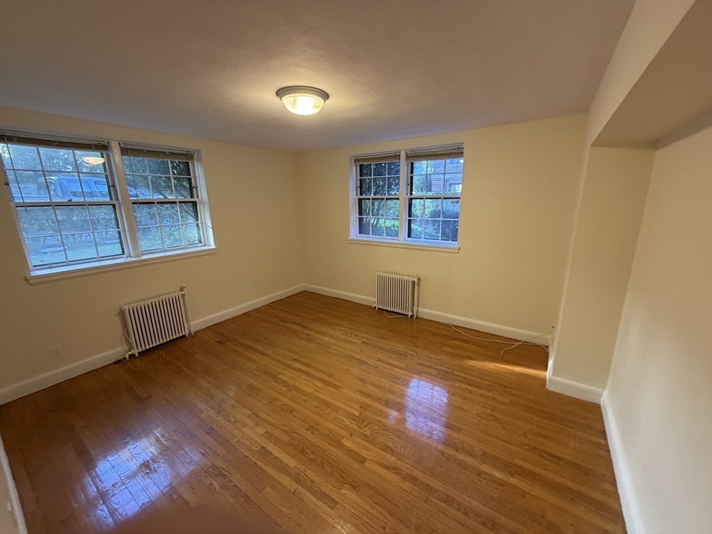12 Kilsyth Terrace, Unit 11 Boston, MA 02135 - Photo 5 of 12 an empty room with wooden floor and windows