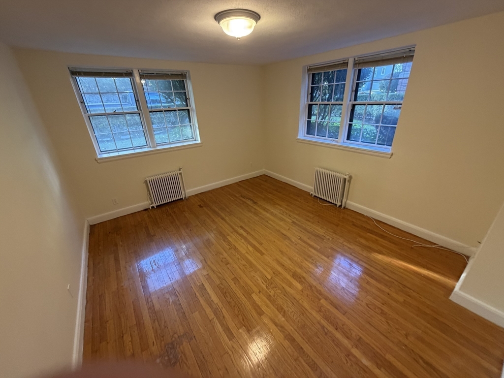 12 Kilsyth Terrace, Unit 11 Boston, MA 02135 - Photo 8 of 12 an empty room with wooden floor and windows