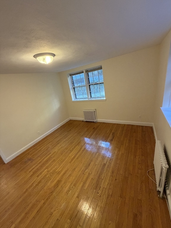 12 Kilsyth Terrace, Unit 11 Boston, MA 02135 - Photo 9 of 12 an empty room with wooden floor and windows