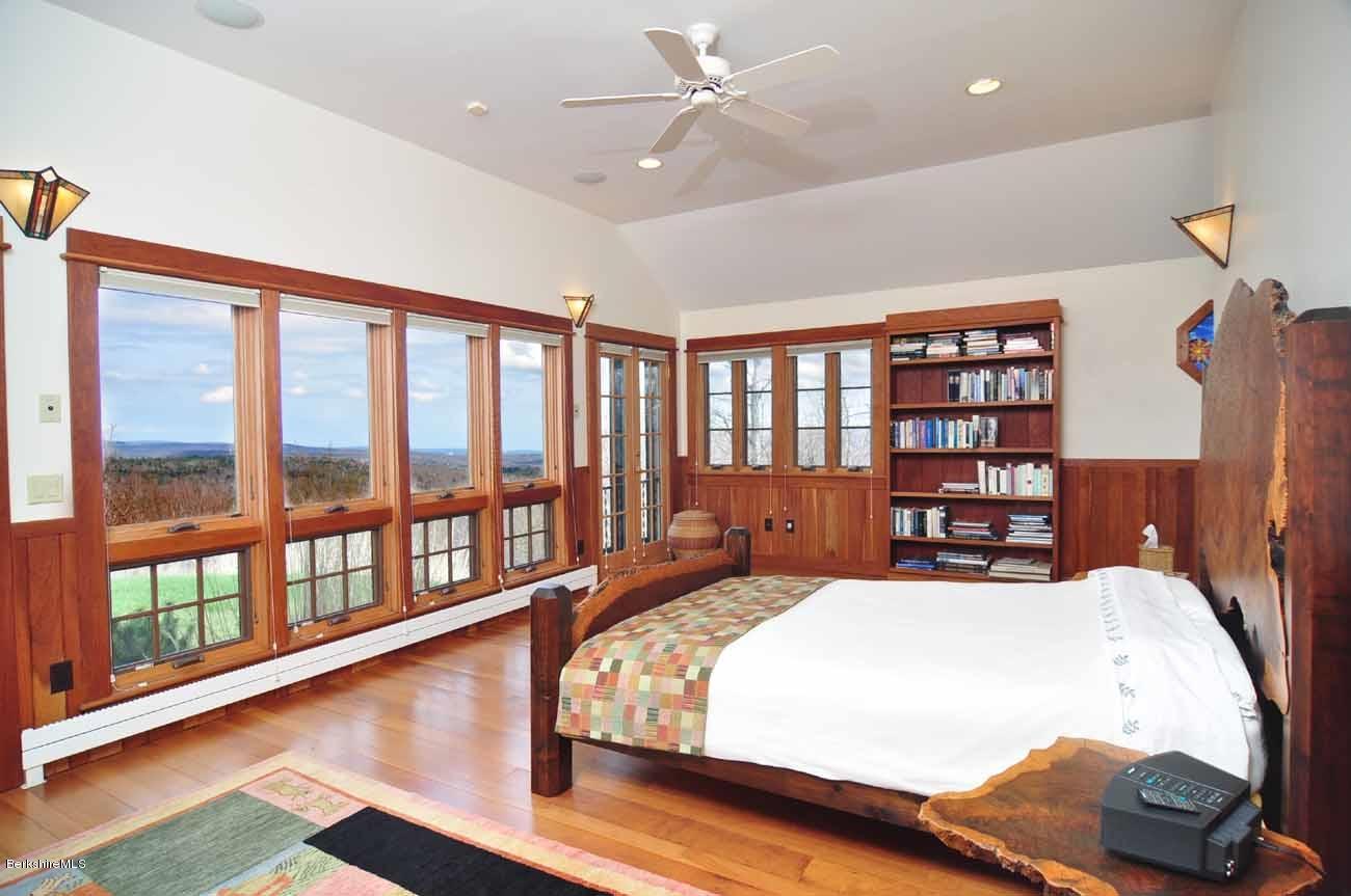 381 Leonhardt Road Becket, MA 01223 - Photo 16 of 47 a bedroom with a large bed and a book shelf