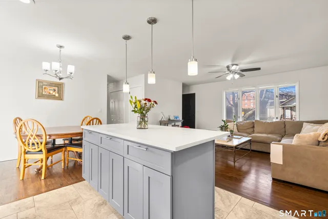 a view of a dining room and livingroom with furniture wooden floor a chandelier
