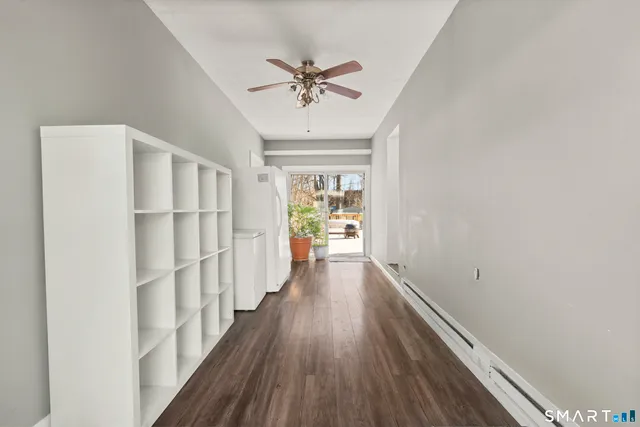 a view of a hallway with wooden floor and a chandelier