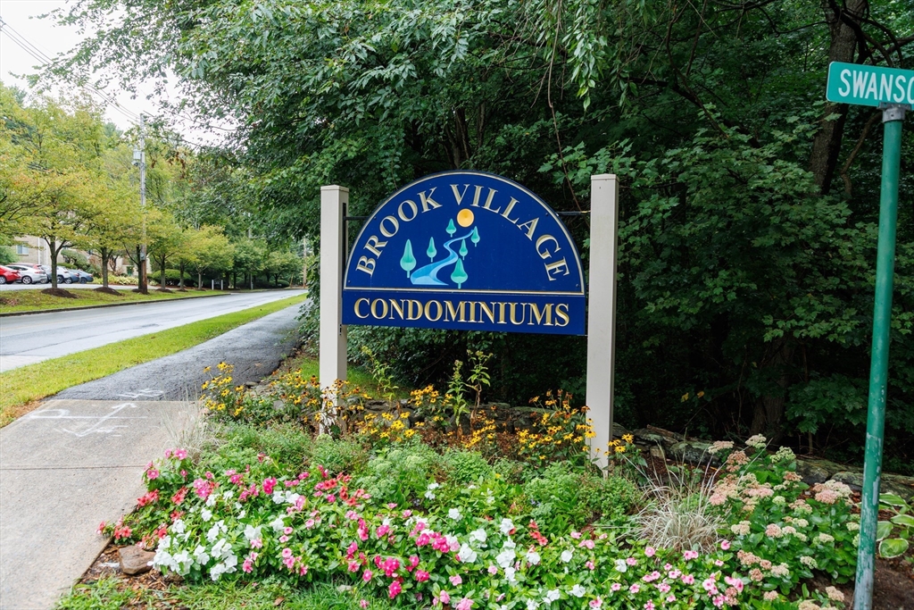 a sign that is sitting in front of flowers