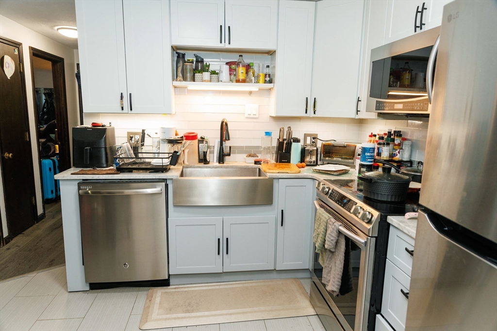 50 Spencer Road, Unit 36L Boxborough, MA 01719 - Photo 14 of 15 a kitchen with stainless steel appliances granite countertop a refrigerator sink stove and white cabinets