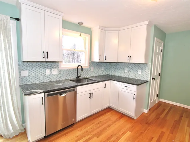 a kitchen with granite countertop white cabinets and white appliances