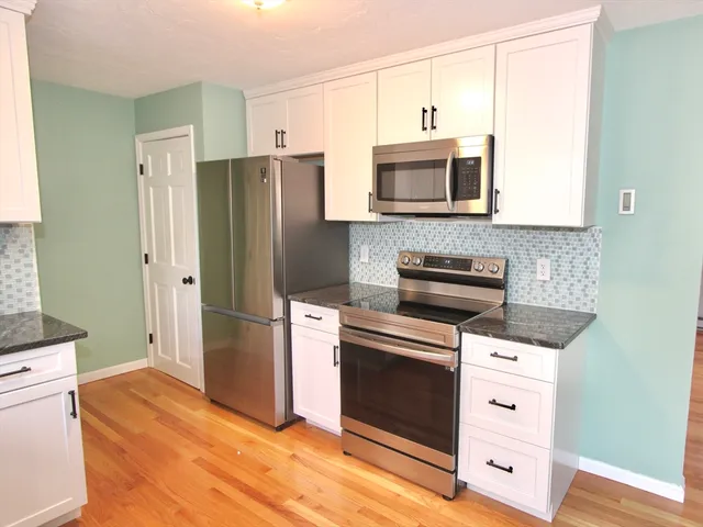 a kitchen with stainless steel appliances a stove a refrigerator and a microwave