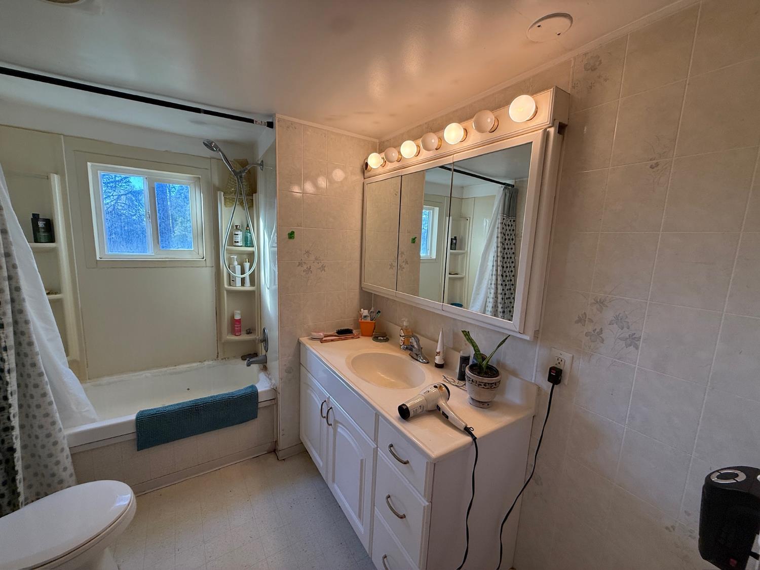 21614 Rockaway Road Nevada City, CA 95959 - Photo 18 of 56 a bathroom with a double vanity sink a toilet a mirror and bathtub
