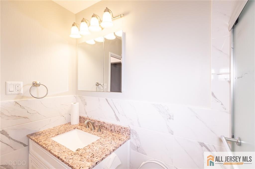187 Evergreen Road, Unit 4B Edison, NJ 08837 - Photo 5 of 8 a bathroom with a granite countertop sink and a mirror