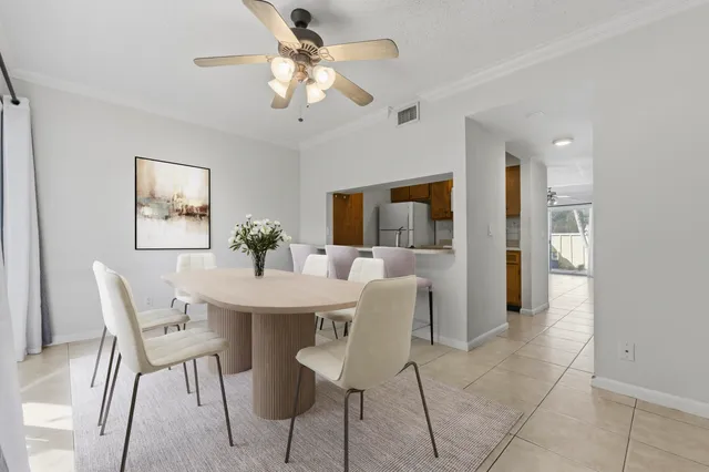 a view of a dining room with furniture and a chandelier fan