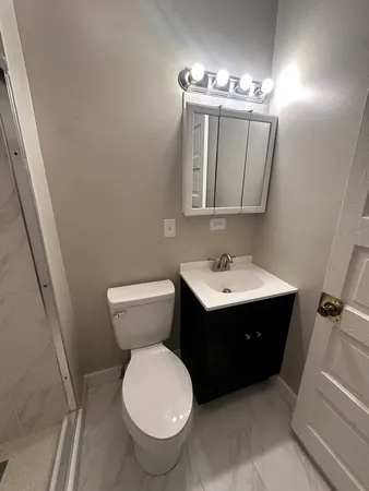 a bathroom with a toilet sink and mirror