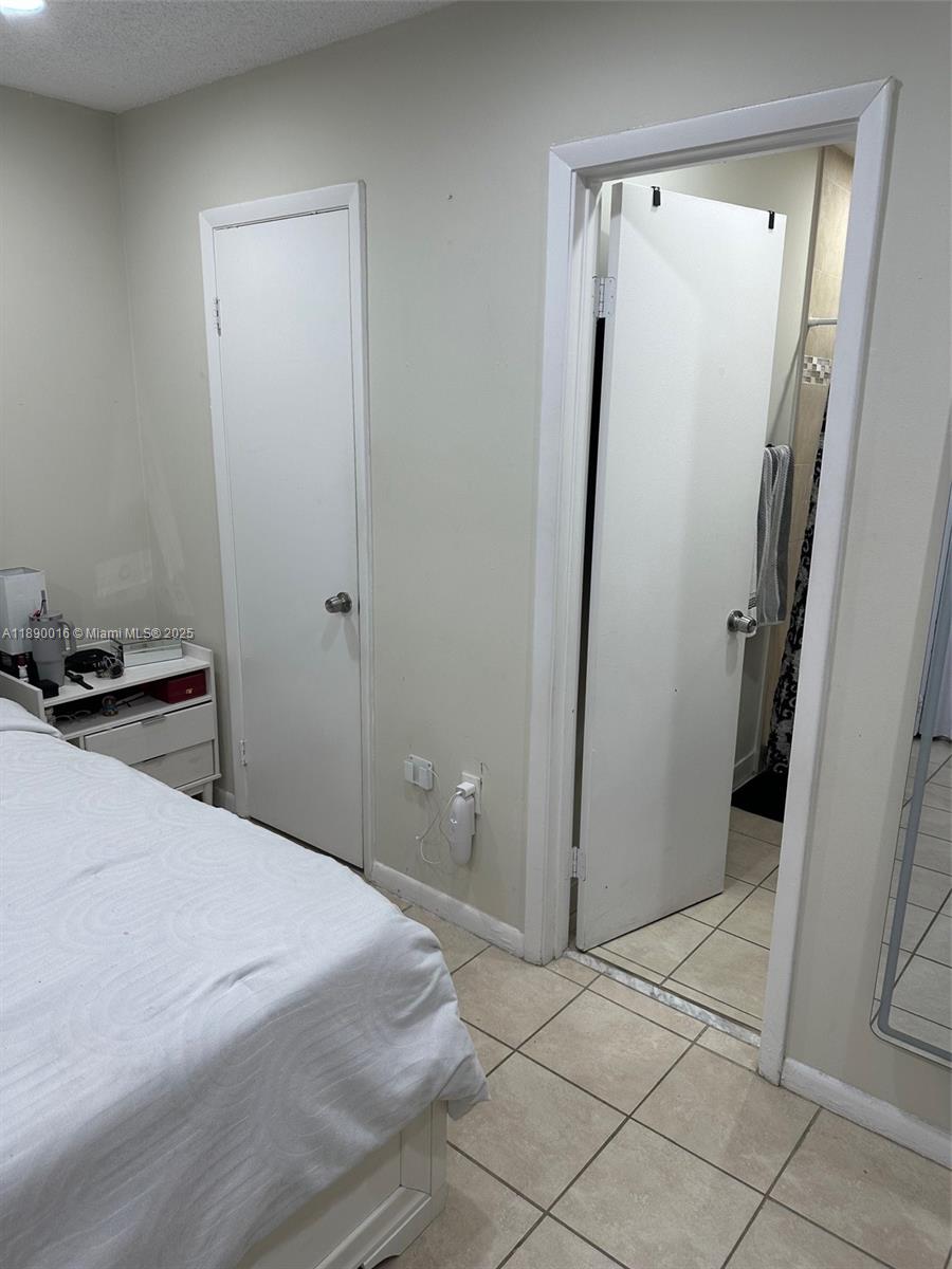 11301 Southwest 200th Street, Unit 305A Miami, FL 33157 - Photo 11 of 26 a bedroom with a bed and a mirror