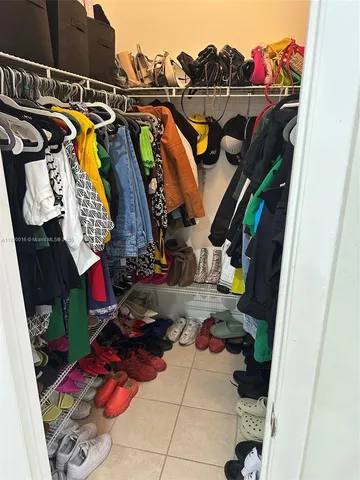 a view of walk in closet with clothes and shoes