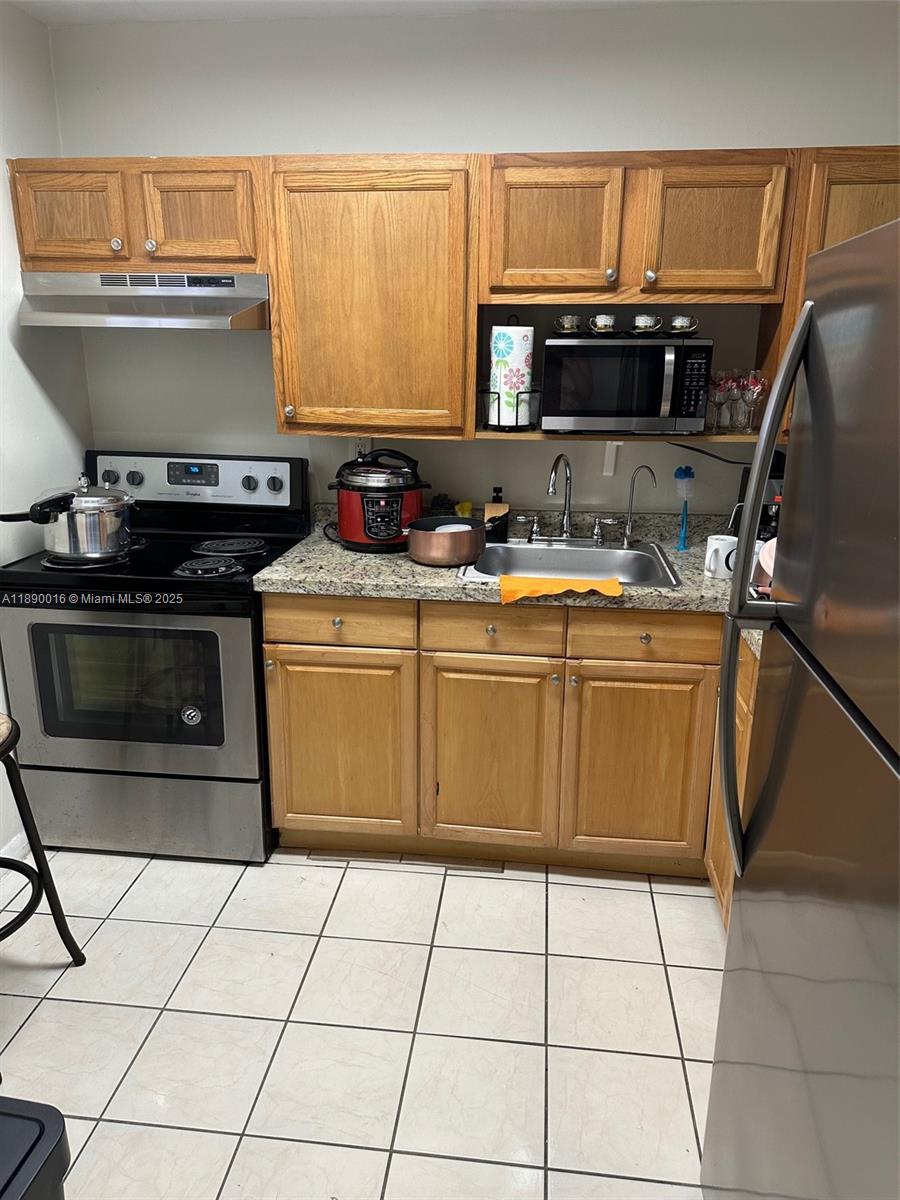11301 Southwest 200th Street, Unit 305A Miami, FL 33157 - Photo 19 of 26 a kitchen with a stove top oven and cabinets