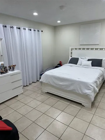 a bedroom with a bed and a curtain