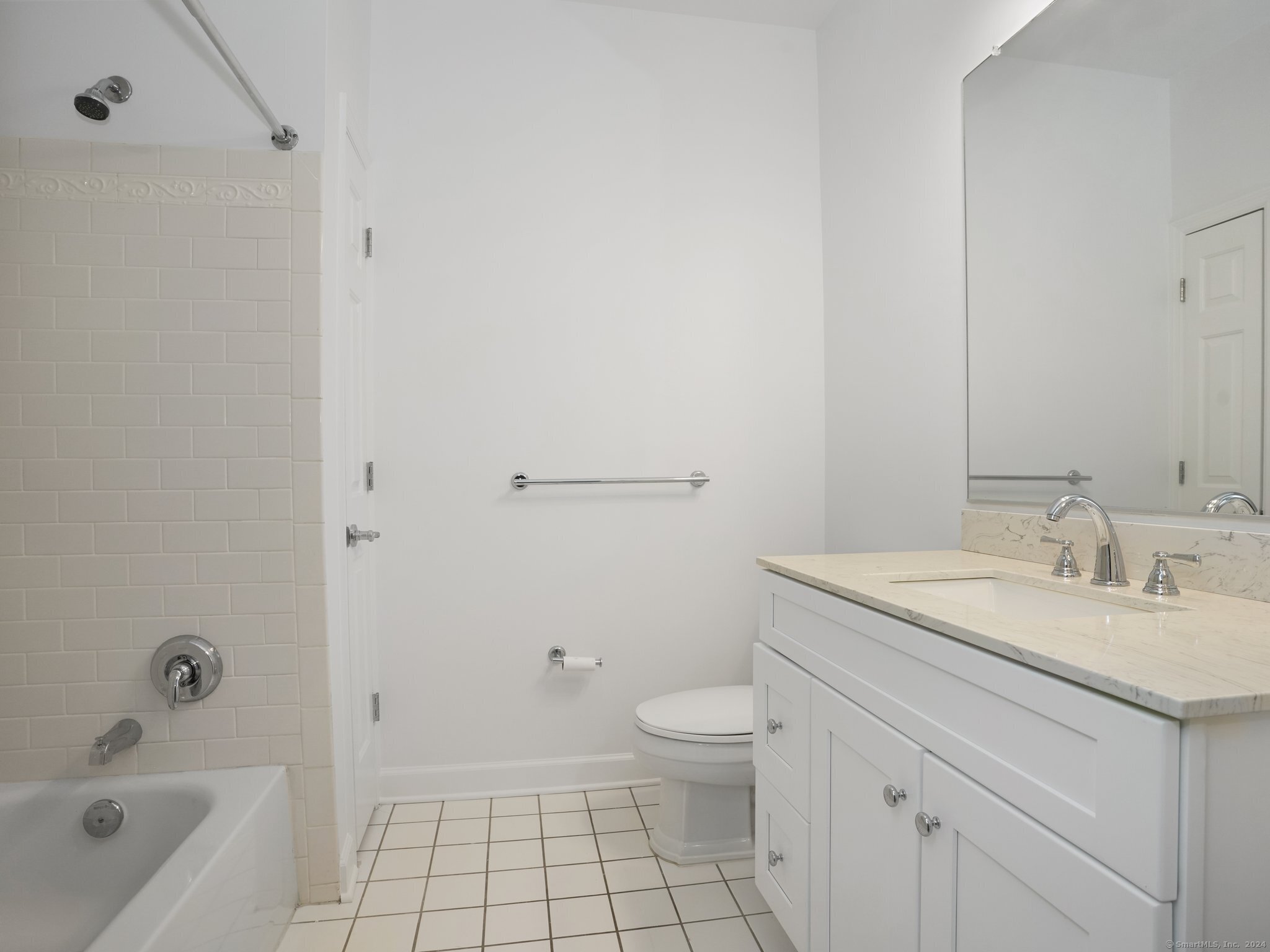 35 West Broad Street, Unit 211 Stamford, CT 06902 - Photo 21 of 38 a bathroom with a granite countertop sink a toilet and bathtub