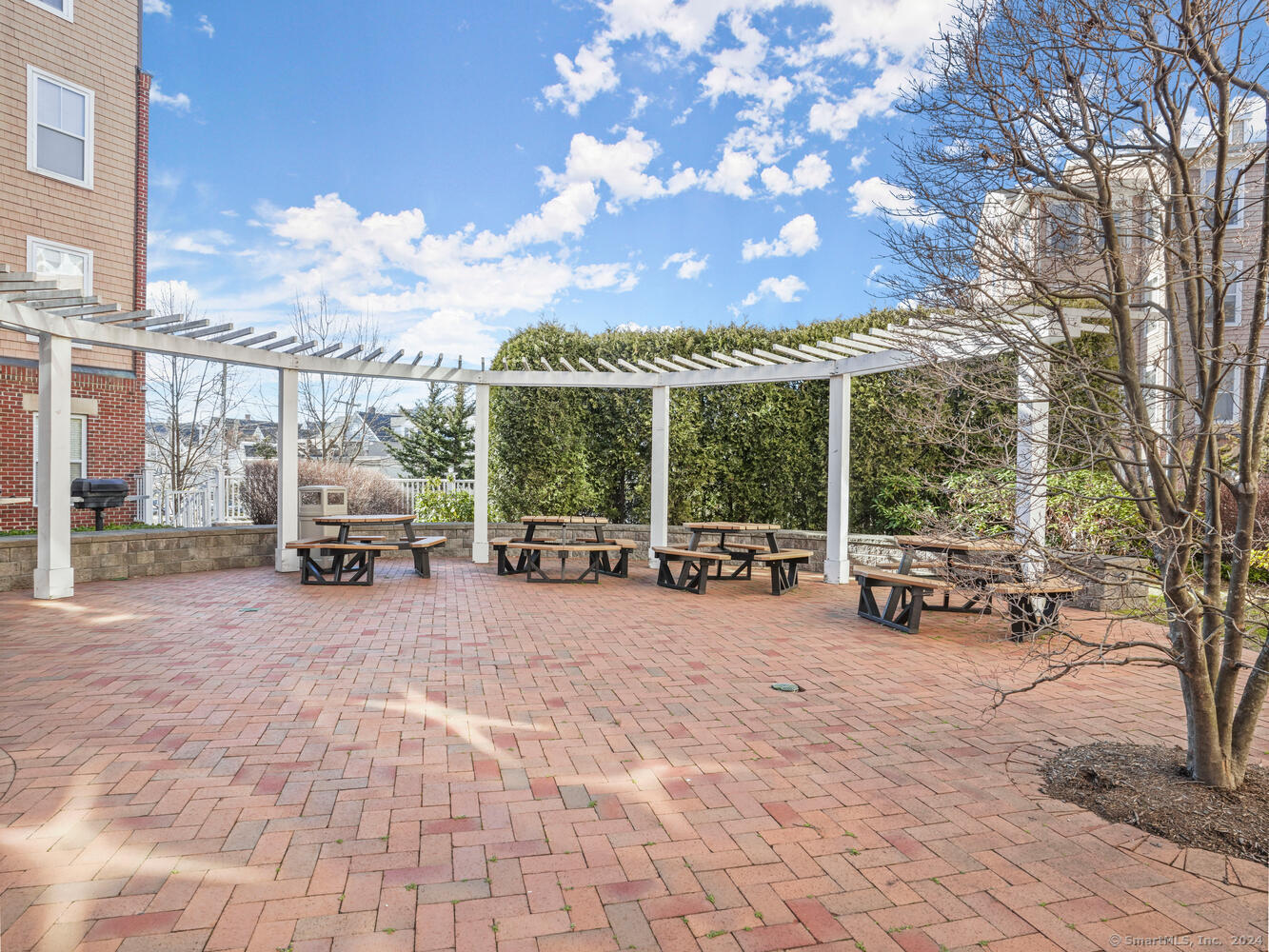 35 West Broad Street, Unit 211 Stamford, CT 06902 - Photo 32 of 38 a view of a patio with table and chairs next to a yard