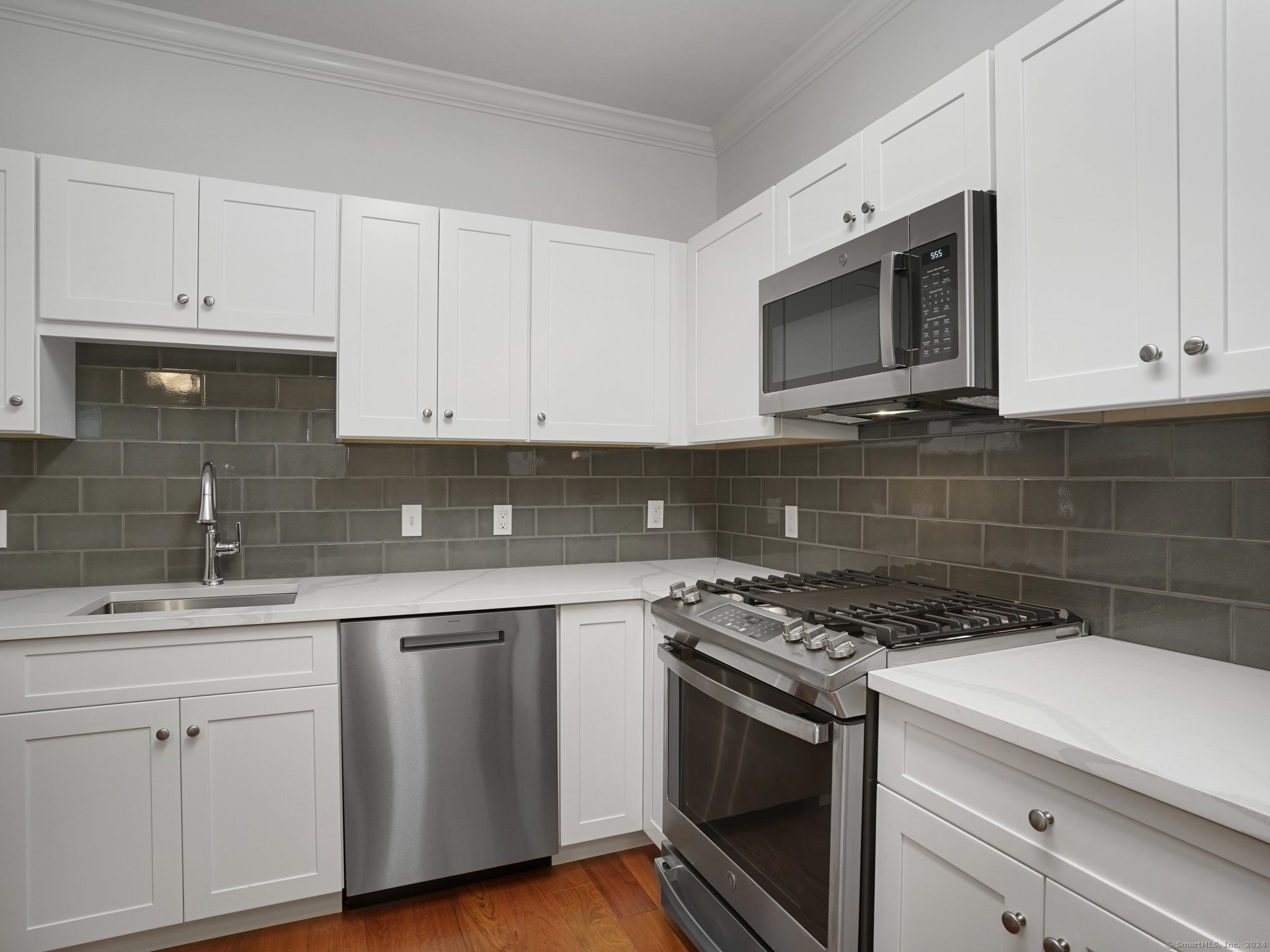 35 West Broad Street, Unit 211 Stamford, CT 06902 - Photo 6 of 38 a kitchen with cabinets stainless steel appliances a sink and a microwave