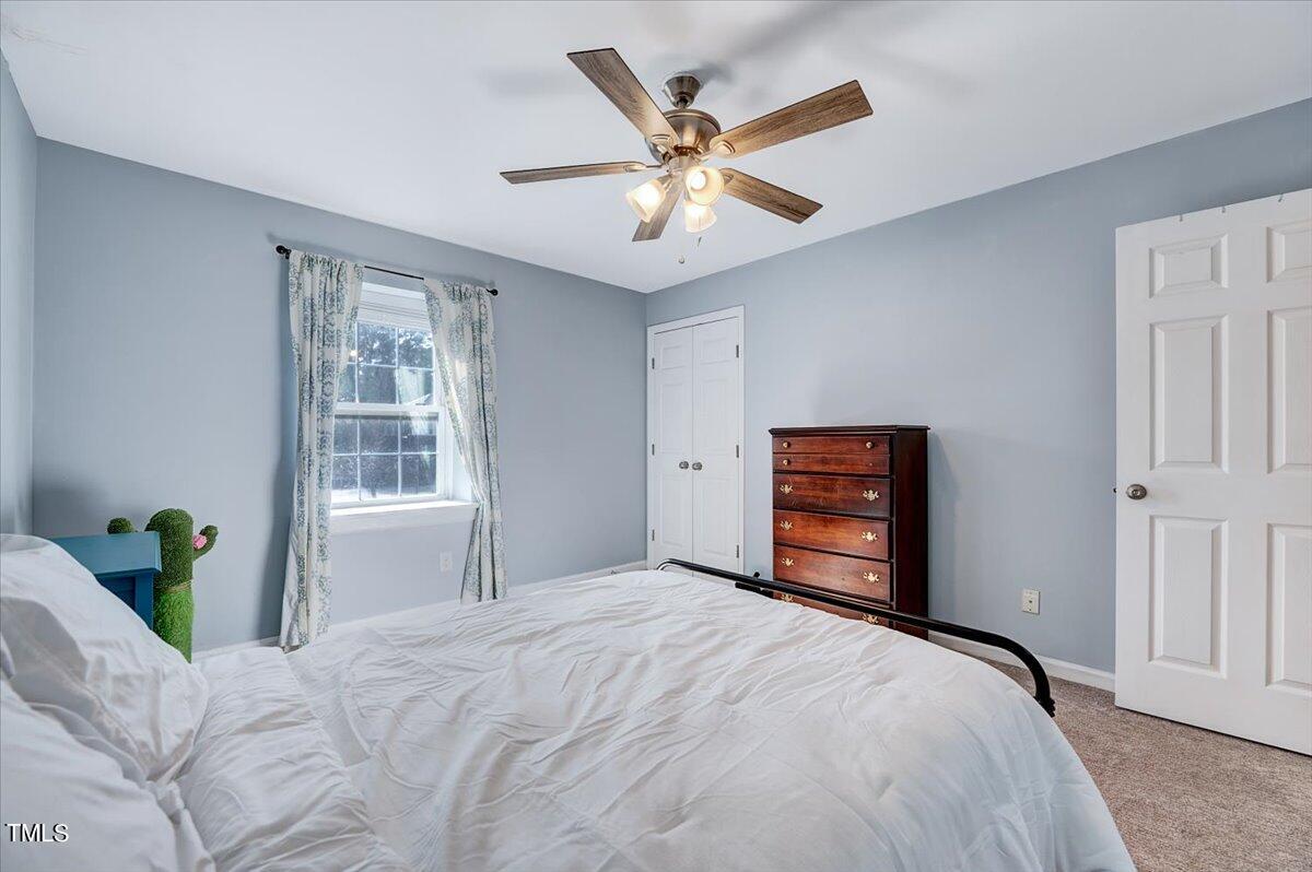 4808 Blue Bird Court, Unit D Raleigh, NC 27606 - Photo 17 of 31 a bedroom with a bed and a chandelier