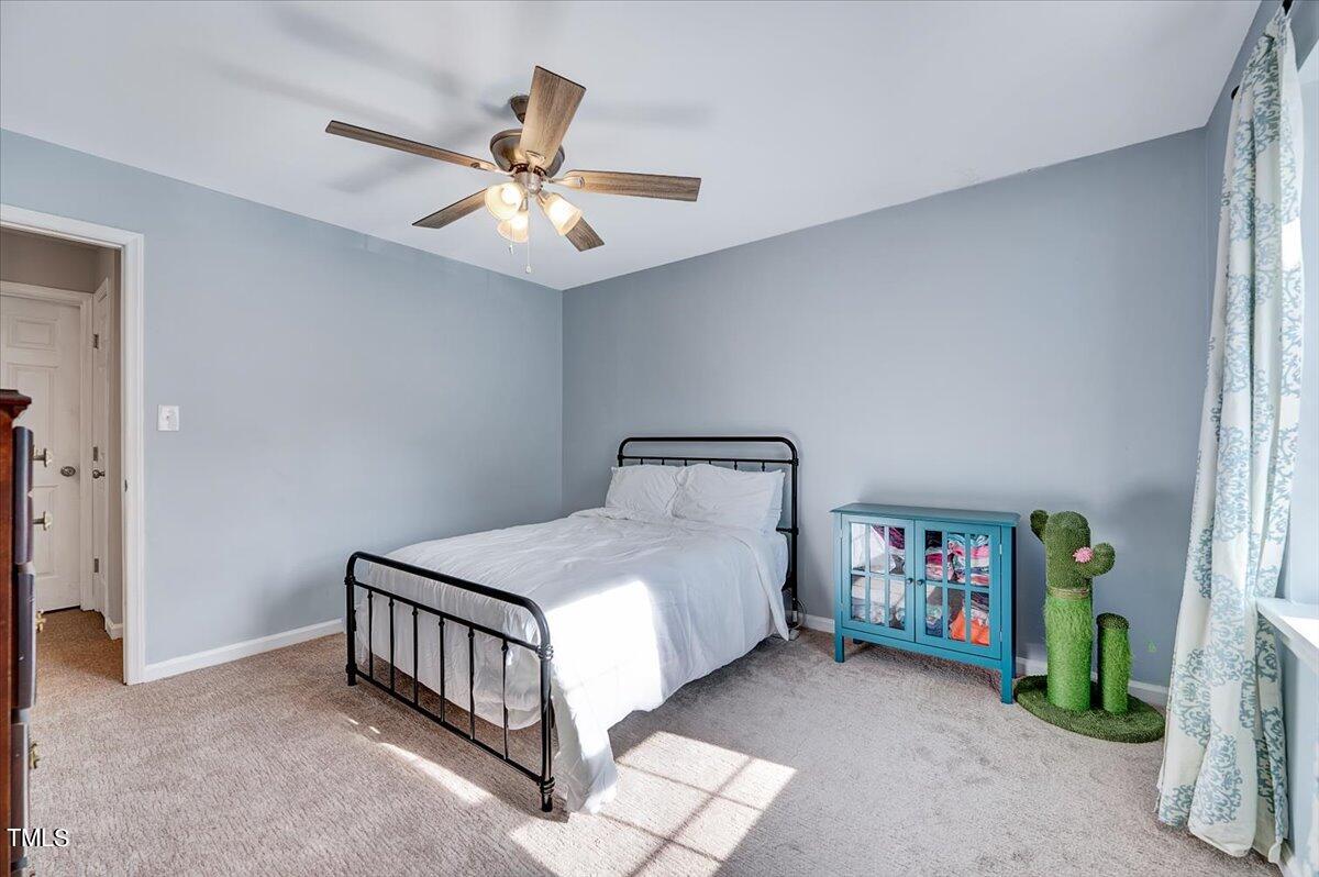 4808 Blue Bird Court, Unit D Raleigh, NC 27606 - Photo 18 of 31 a bedroom with a bed and a chandelier