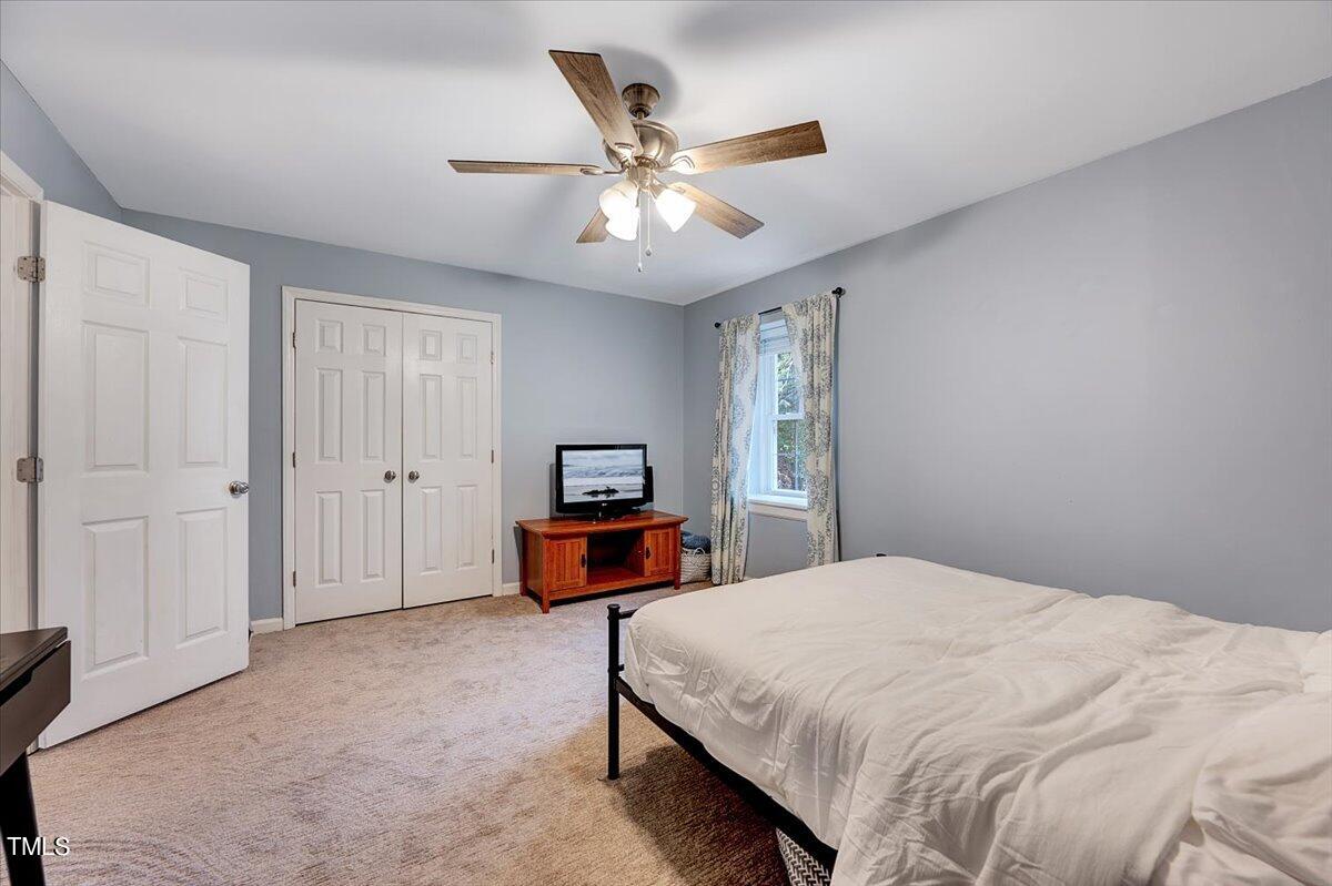 4808 Blue Bird Court, Unit D Raleigh, NC 27606 - Photo 20 of 31 a bedroom with a bed and ceiling fan