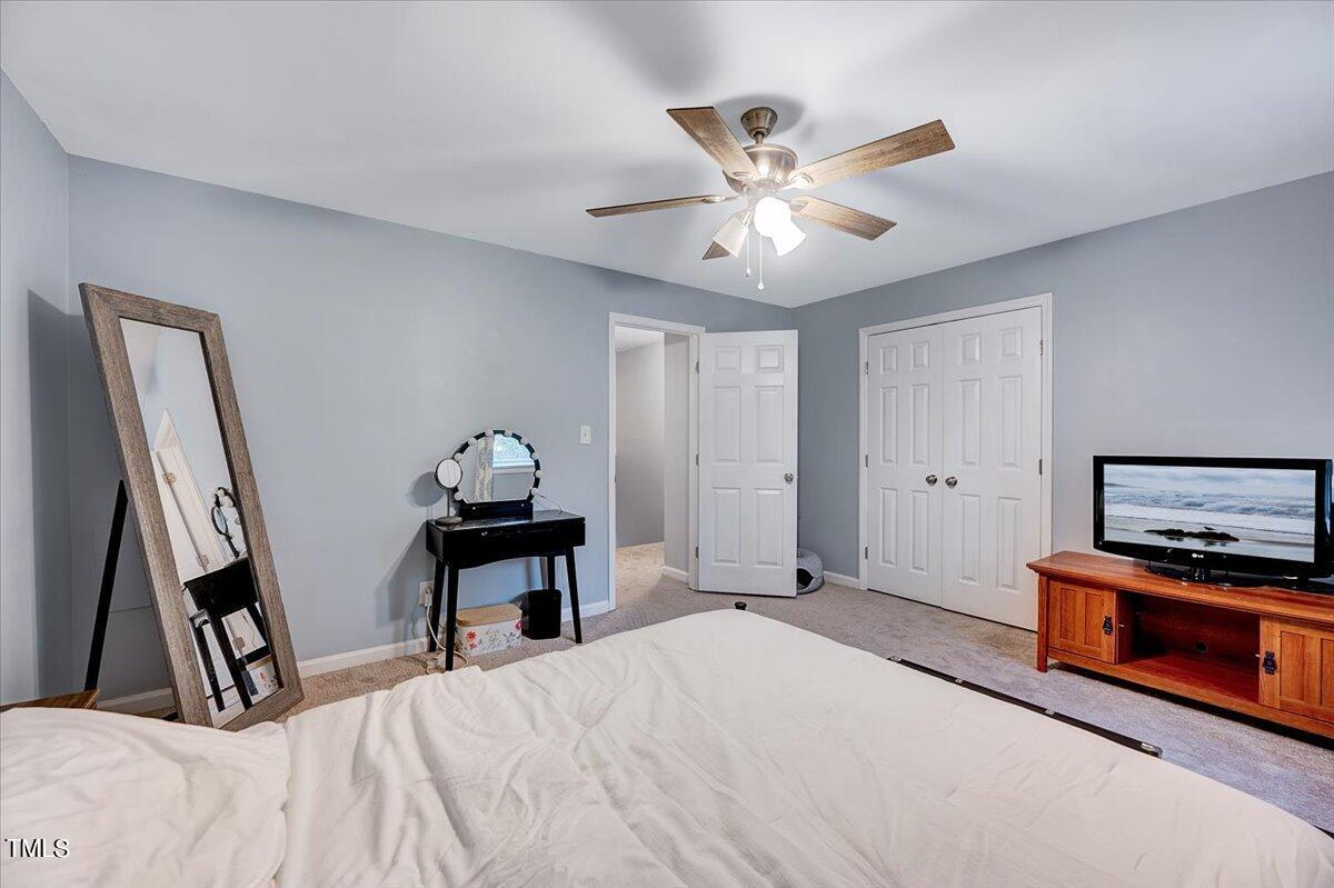 4808 Blue Bird Court, Unit D Raleigh, NC 27606 - Photo 21 of 31 a bedroom with a bed and a chandelier