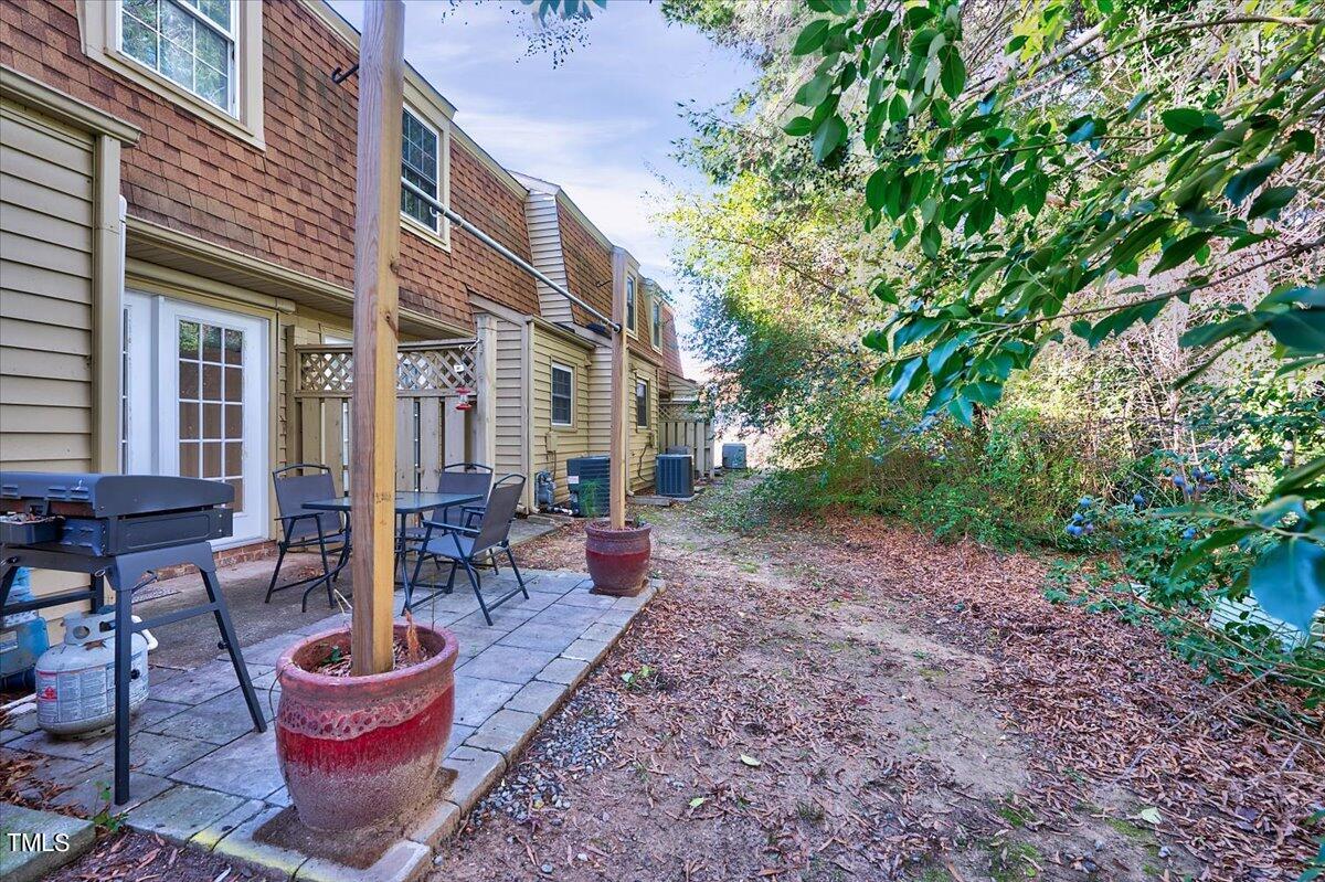 4808 Blue Bird Court, Unit D Raleigh, NC 27606 - Photo 23 of 31 a backyard of a house with barbeque oven table and chairs